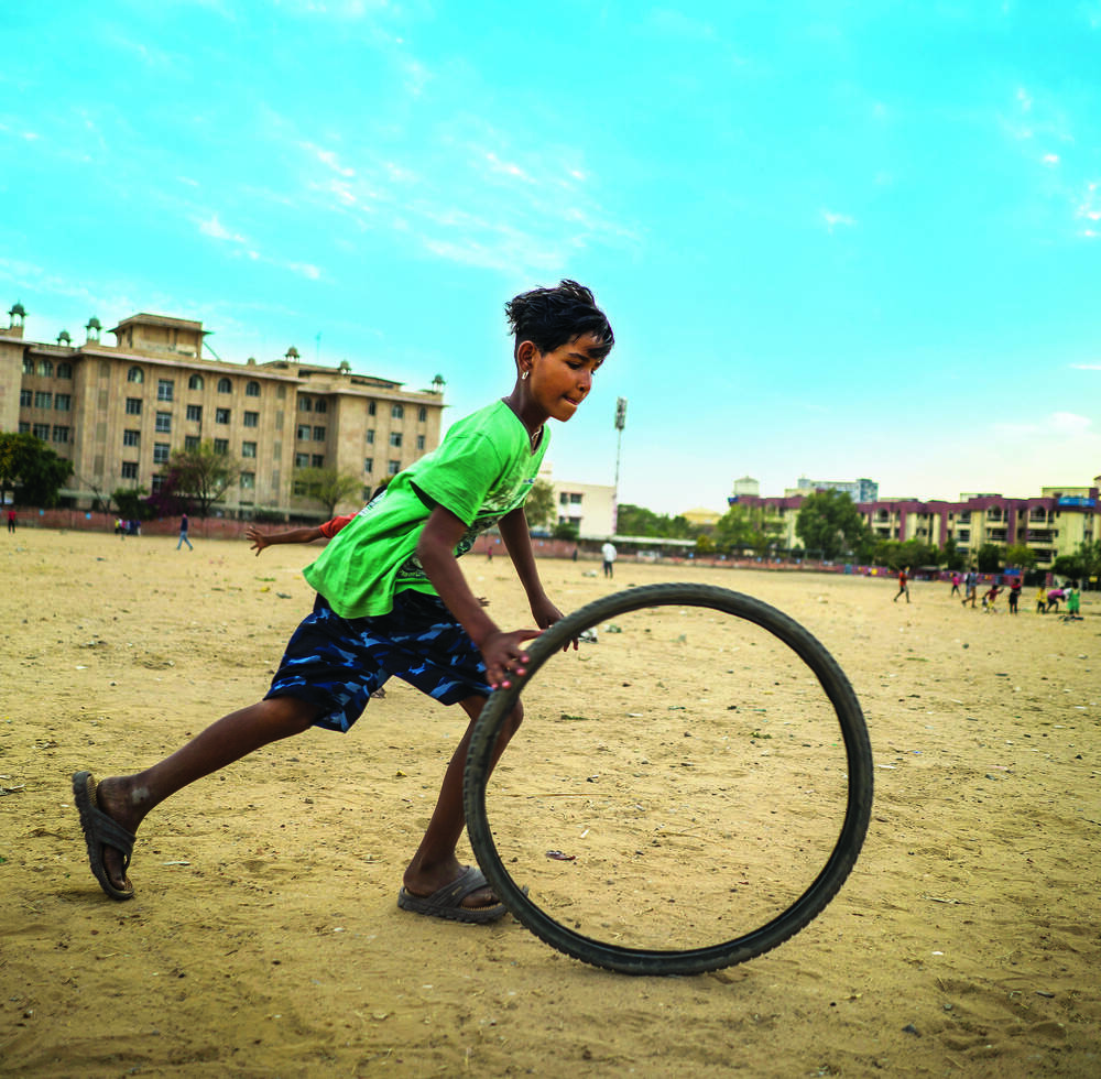 A girl play with a bycicle wheel